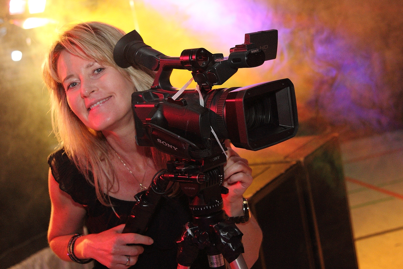 Marion Kopietz mit professioneller Videokamera vor der Chiemgauer Berglandschaft